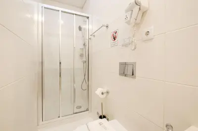 a white bathroom with a shower and a toilet at GuestReady - Port Studio 4 in Vila Nova de Gaia