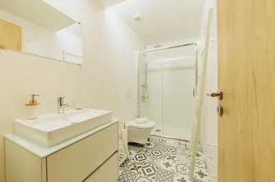 a white bathroom with a sink and a toilet at Ribeira Charming Apartment in Porto