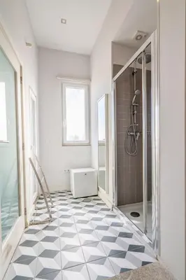 a bathroom with a shower and a tiled floor at Host Wise - Sweet Bright Flats - City Center in Porto