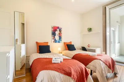 a bedroom with two beds with red blankets at Host Wise - Sweet Bright Flats - City Center in Porto