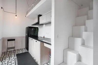 a kitchen with white cabinets and a black refrigerator at GuestReady - Cosy in the Historic Heart of Porto in Porto