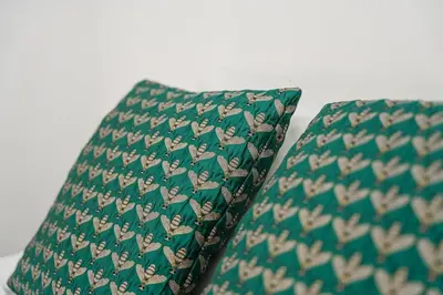 a green pillow with a bird pattern on it at GuestReady - Cosy in the Historic Heart of Porto in Porto