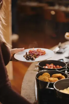 a person holding a plate of food on a table at Timbre Virtudes in Porto