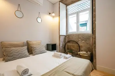 a bedroom with a large bed and a window at Charming T2 by Indulge Porto Flats in Porto