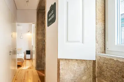 a hallway with a white door and a living room at Charming T2 by Indulge Porto Flats in Porto