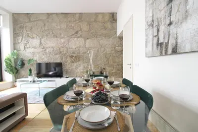 a dining room with a table and green chairs at Porto Unique Downtown Garden in Porto