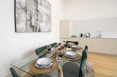 a dining room with a glass table and green chairs at Porto Unique Downtown Garden in Porto