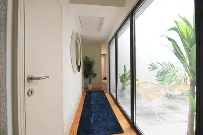 a hallway with a door and a blue rug at Porto Unique Downtown Garden in Porto