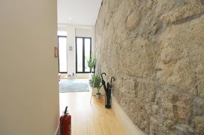 a room with a stone wall and a hallway at Porto Unique Downtown Garden in Porto