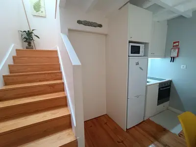 a small kitchen with a staircase and a refrigerator at Duke Street Guest House in Porto