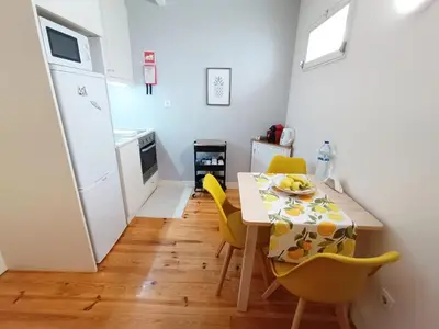 a small kitchen with a table and yellow chairs at Duke Street Guest House in Porto