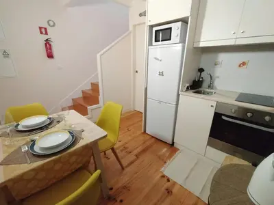 a small kitchen with a table and yellow chairs at Duke Street Guest House in Porto