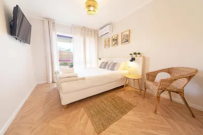 a bedroom with a bed and a tv and a chair at CityLiving in Porto