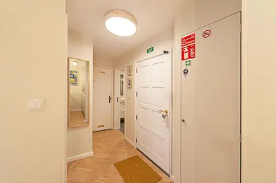 a hallway with a white door and a sign on the wall at CityLiving in Porto