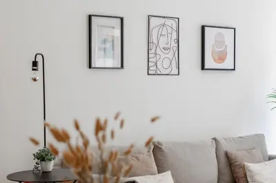 a living room with a couch and four pictures on the wall at Virtudes Flat w/ AC & Balcony by LovelyStay in Porto