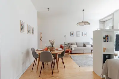 a dining room and living room with a table and chairs at Virtudes Flat w/ AC & Balcony by LovelyStay in Porto