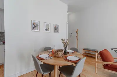 a dining room with a wooden table and chairs at Virtudes Flat w/ AC & Balcony by LovelyStay in Porto