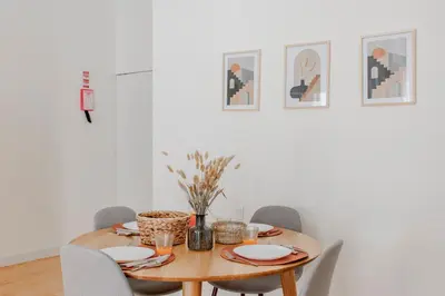 a dining room with a wooden table and chairs at Virtudes Flat w/ AC & Balcony by LovelyStay in Porto