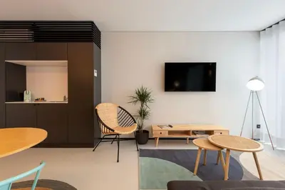 a living room with tables and a tv on a wall at Blau 1911 in Porto