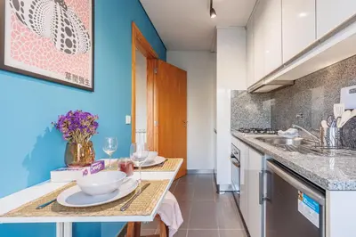 a living room with a couch and a tv at A Pop of Color by LovelyStay in Porto