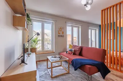 a living room with a red couch and a tv at A Pop of Color by LovelyStay in Porto
