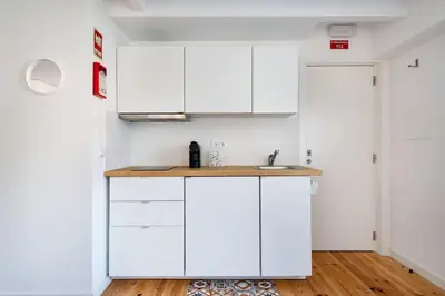 a kitchen with white cabinets and a sink at Casa Flora in Porto