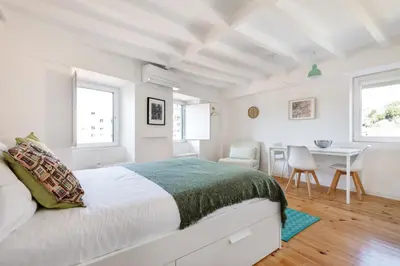 a white bedroom with a bed and a table at Casa Flora in Porto