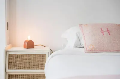 a white bed with a pink pillow and a night stand at Sunshine Luxury House Urban Retreat Downtown Porto in Porto