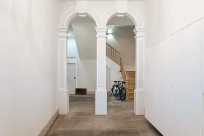 a hallway with white walls and a staircase with a bike at Sunshine Luxury House Urban Retreat Downtown Porto in Porto