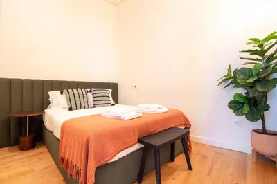 a bedroom with a bed with an orange blanket on it at Mouzinho da Silveira 215 by LovelyStay in Porto