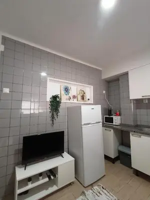 a kitchen with a refrigerator and a tv in it at Ap Centro de Gaia in Vila Nova de Gaia