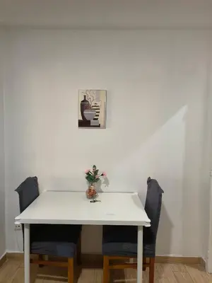a white table with two chairs and a vase on it at Ap Centro de Gaia in Vila Nova de Gaia