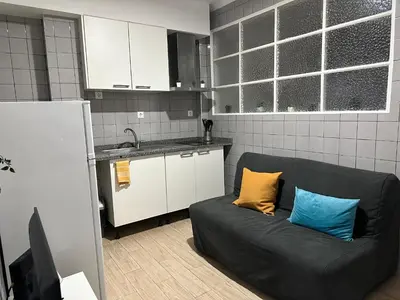 a black couch with two blue and yellow pillows in a kitchen at Ap Centro de Gaia in Vila Nova de Gaia