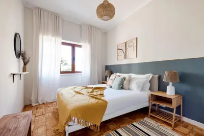 a bedroom with a white bed and a blue wall at Trendy and Modern 3BR Family Home in Porto