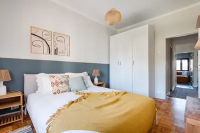 a bedroom with a bed with a yellow blanket on it at Trendy and Modern 3BR Family Home in Porto