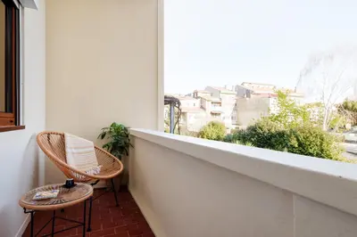 two chairs sitting on a balcony looking out of a window at Trendy and Modern 3BR Family Home in Porto