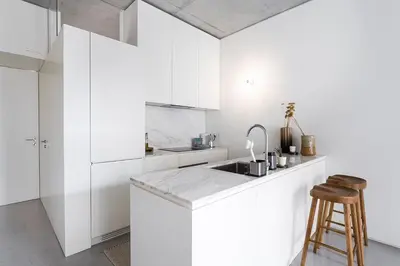 a white kitchen with a sink and a counter at GuestReady - The Modern Silveira in Porto