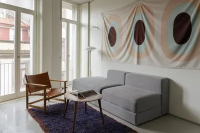 a living room with a couch and a chair at GuestReady - The Modern Silveira in Porto