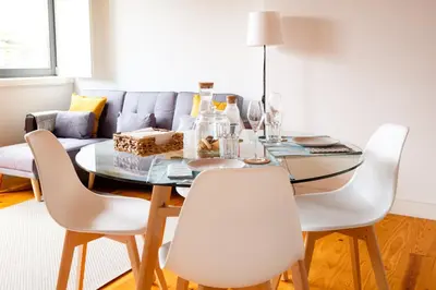 a dining room with a table and white chairs at PortoDise Loft by RDC in Porto