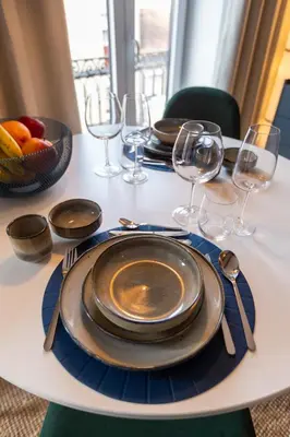 a table with plates and glasses and a bowl of fruit at OPO Vale Formoso I in Porto