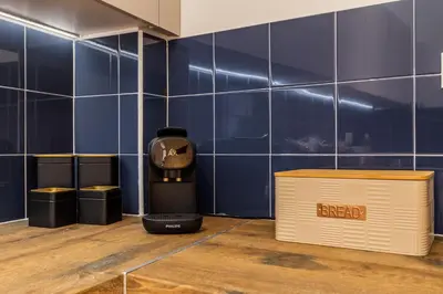 a coffee maker and a box in a room with blue tiles at OPO Vale Formoso I in Porto