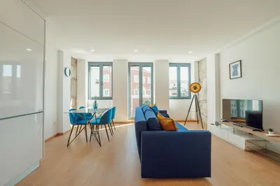 a living room with a blue couch and a table at Modern & Stylish Apartments by Vacationy in Porto