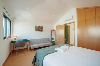 a bedroom with a large white bed and a couch at Modern & Stylish Apartments by Vacationy in Porto