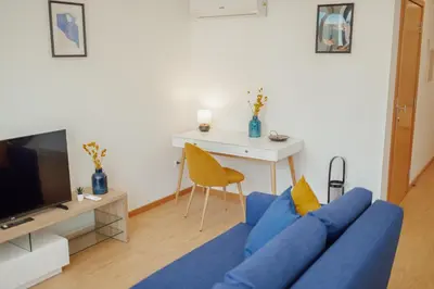 a living room with a blue couch and a table at Modern & Stylish Apartments by Vacationy in Porto