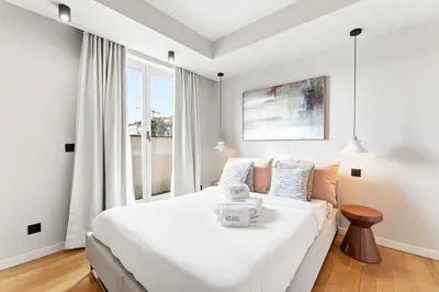 a bedroom with a large white bed and a window at GuestReady - Blue shades with panoramic city views in Porto