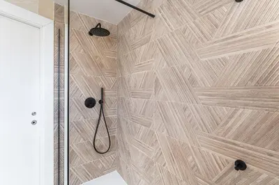 a bathroom with a shower with a wooden wall at GuestReady - Blue shades with panoramic city views in Porto