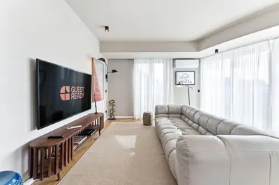 a living room with a couch and a flat screen tv at GuestReady - Blue shades with panoramic city views in Porto