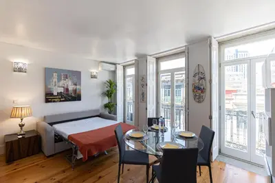 a room with a bed and a table and chairs at Lovely Bonfim in Porto