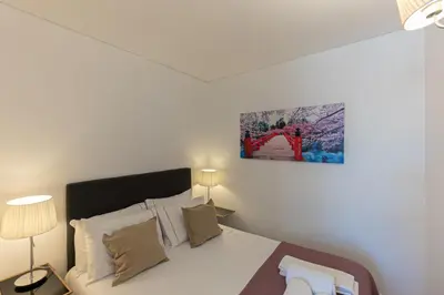 a bedroom with a bed and a painting on the wall at Lovely Bonfim in Porto