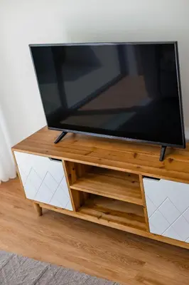 a flat screen tv on a wooden tv stand at Pestana Apartments - Premium in Porto